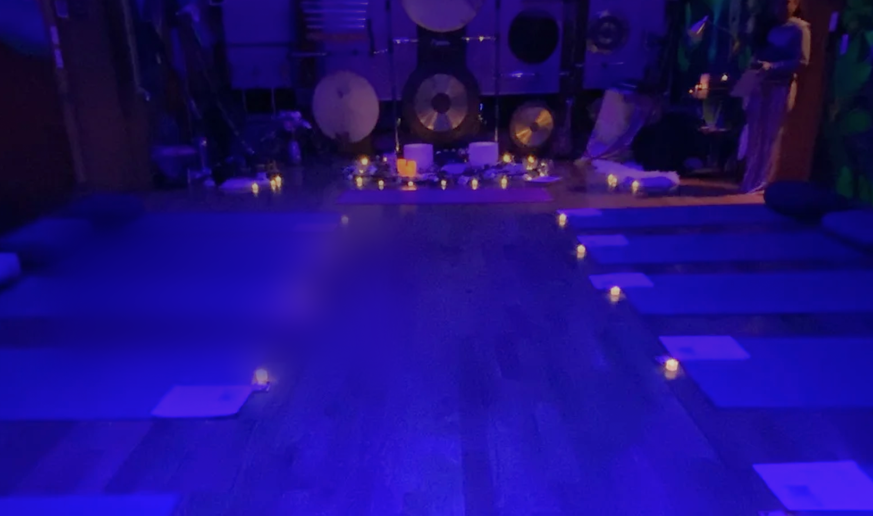 The Yoga Room at SoderWorld, mats and singing bowls arranged in low candlelight